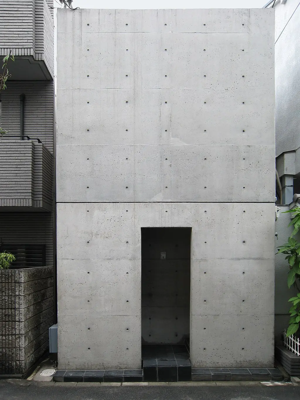 Azuma House, a minimalist concrete row house in Sumiyoshi, Osaka, showcasing Tadao Ando’s signature modernist design with open courtyards and sharp lines.