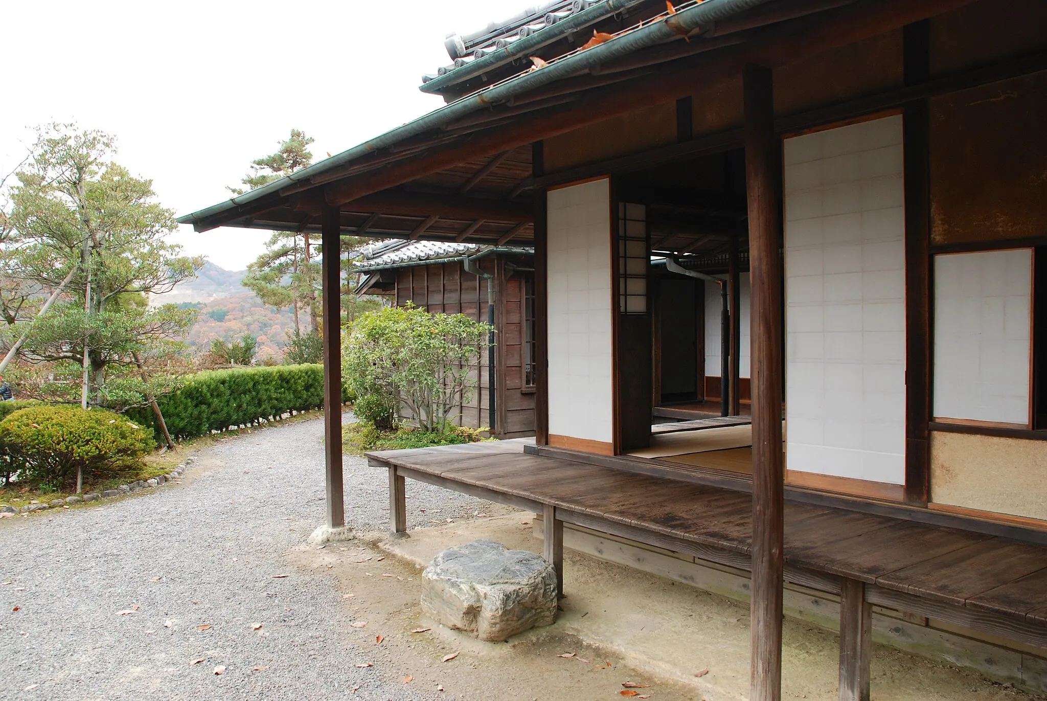 Japanese house with an engawa, showing wet surroundings after rain, with dry eaves and foundations protected by the traditional design.