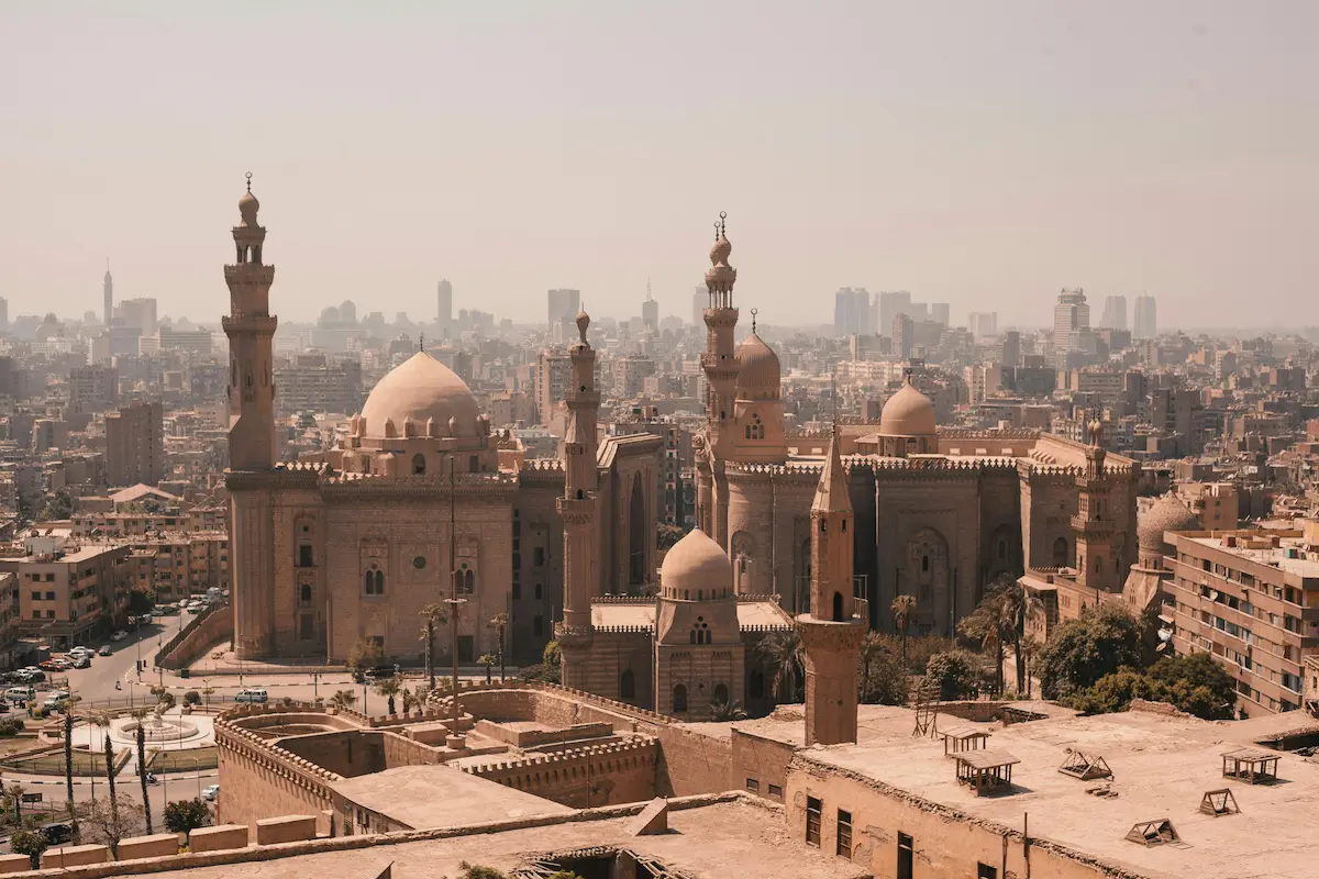 Aerial view of Old Islamic Cairo, featuring numerous mosques with towering minarets and historic buildings.