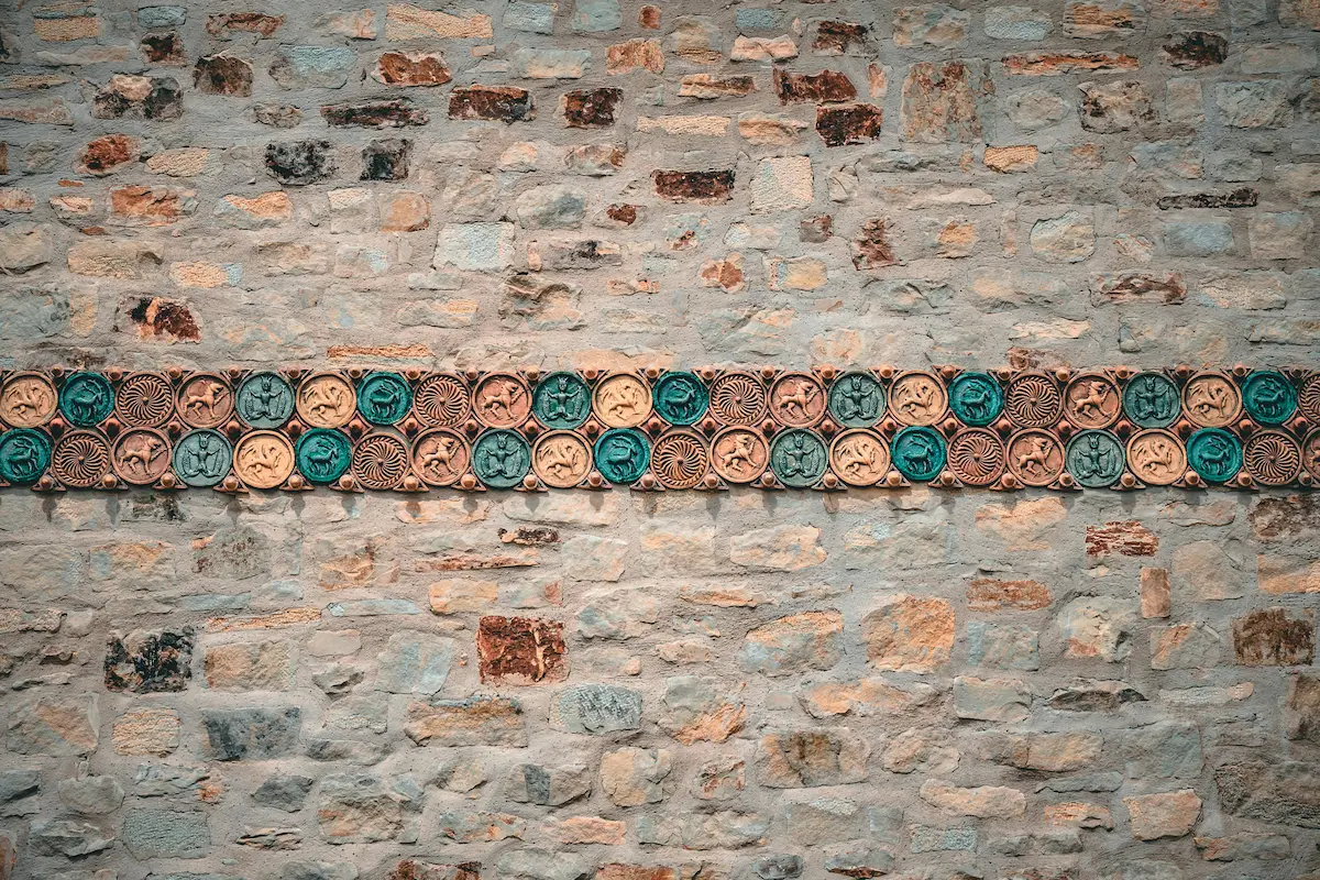A brown concrete wall exemplifies Arts and Crafts architecture with its textured surface.