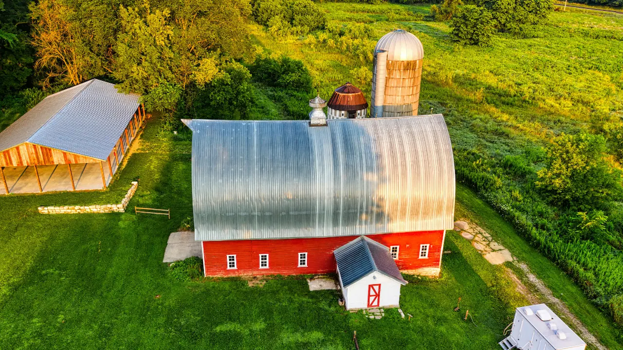 aerial view of a barndominium on a farm with surrounding fields
