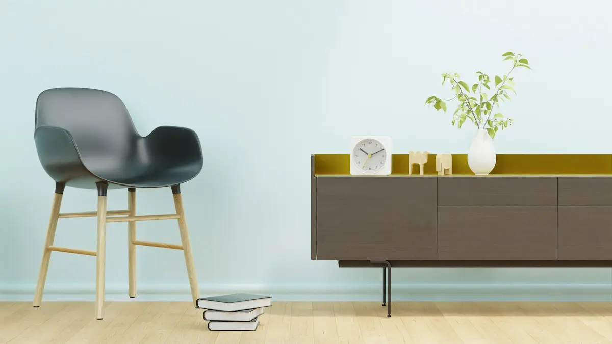 A stack of books placed next to a black chair in a minimalist living room, adding a touch of style and simplicity to the space.