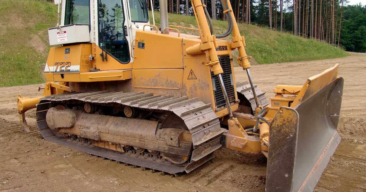 bulldozer pushing soil and grading a surface on a construction site