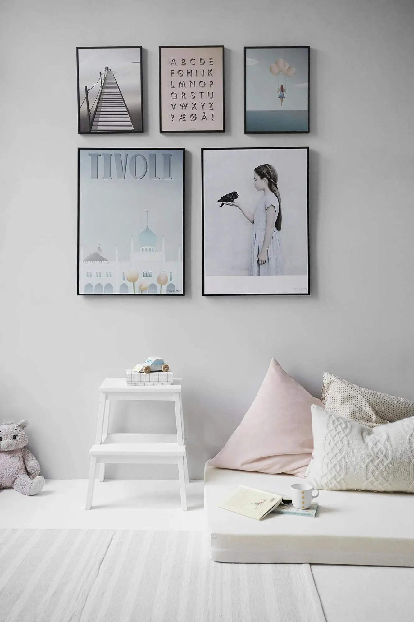 Minimal bedroom using white color-drenching with subtle pastel accents to create a spacious look.