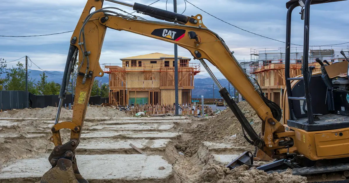 construction site with an excavator performing foundation excavation