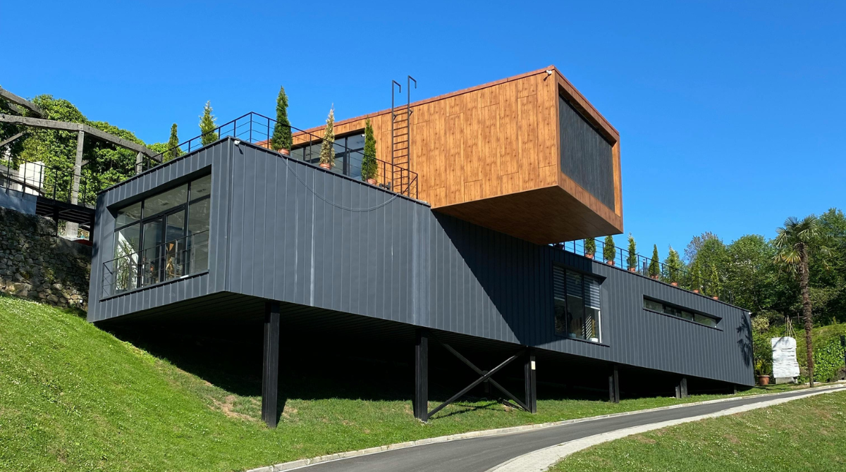 a modern architectural house constructed using cargo containers, featuring an innovative design with clean lines and large glass windows