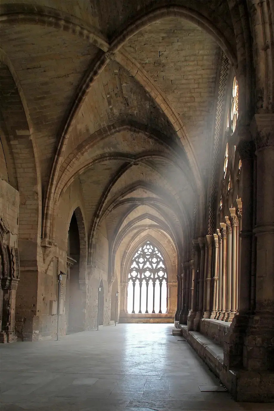 Interior of a Gothic structure, showcasing natural lighting filtered through Islamic design elements like arches and lattices.