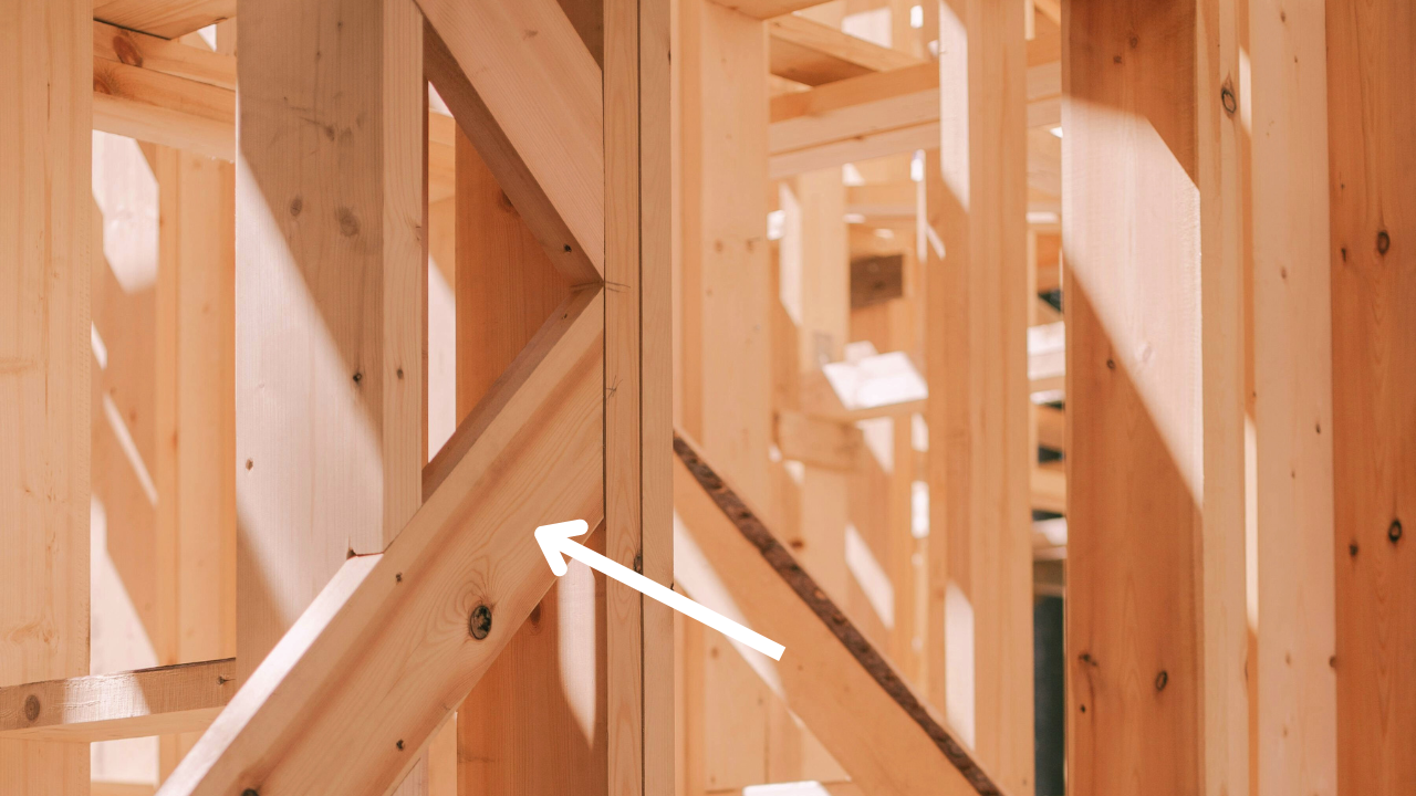 Close-up of a house frame showcasing visible diagonal truss bracing for structural support.