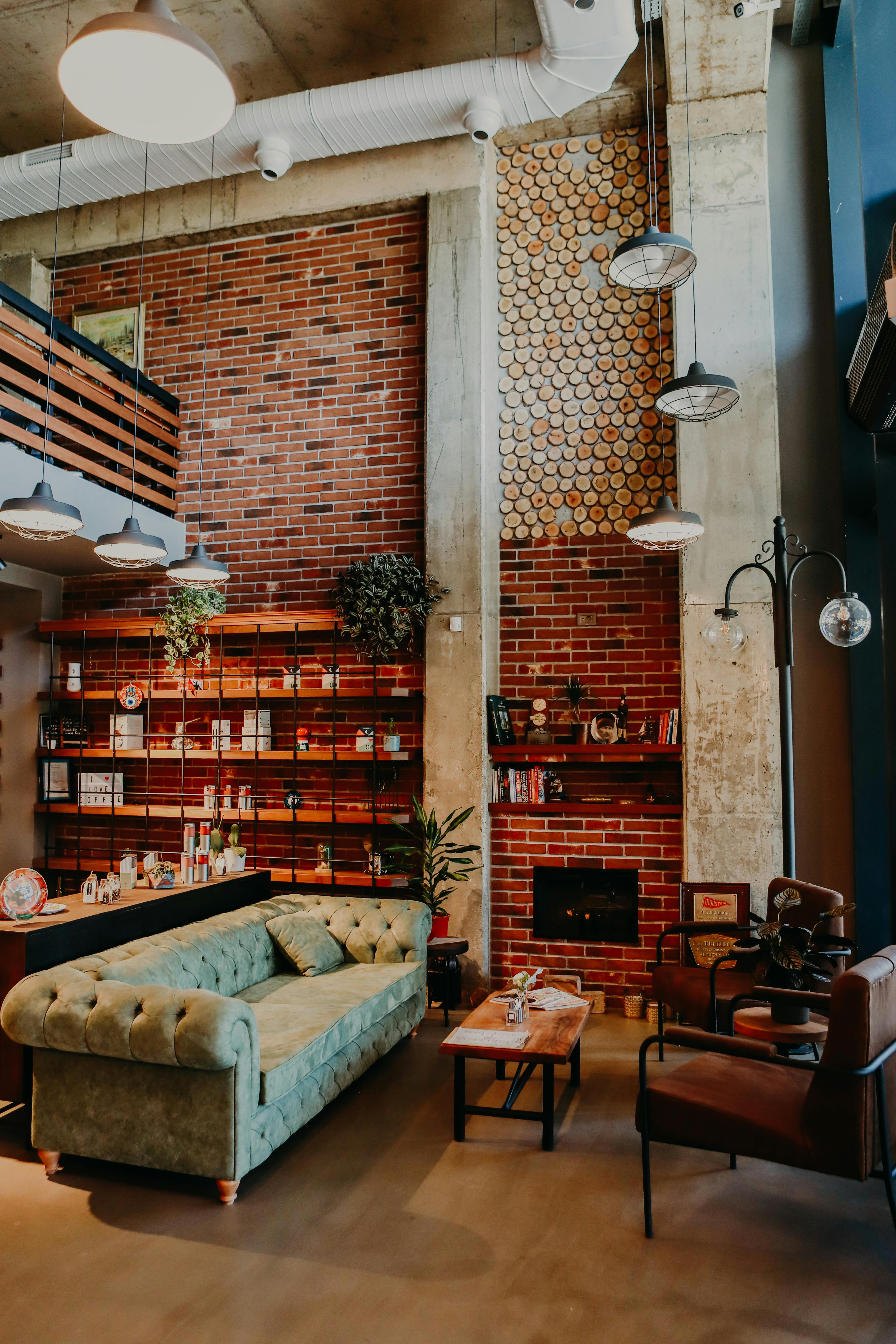 Industrial living room with sofa, coffee table, exposed bricks, and visible pipes.