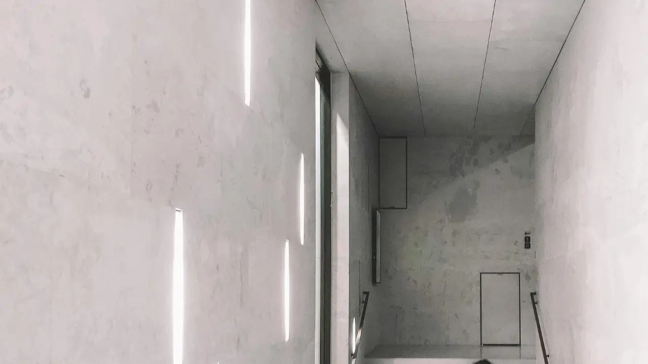 A contemporary concert building with innovative natural lighting methods illuminating the staircase, creating captivating light patterns on the walls