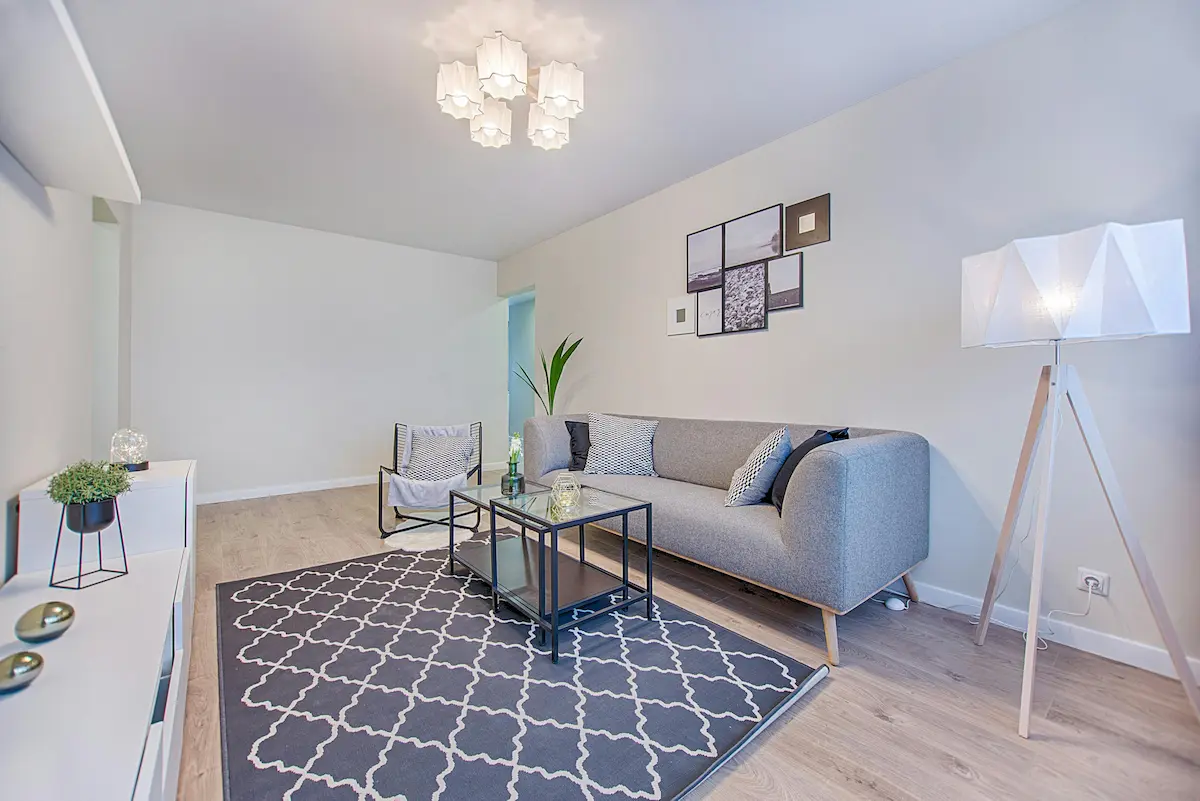 Layered lighting with wall sconces, floor lamps, and LED strips to create a cozy and flexible ambiance in the room.
