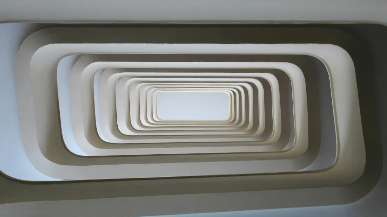 Modern stairwell in Lyon, France, showcasing sleek design with abundant natural lighting from below