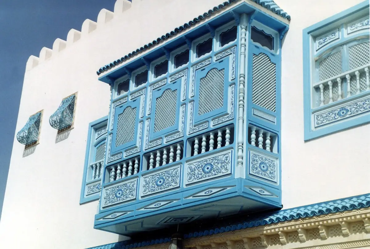 Mashrabiya screens in Islamic architecture, designed for privacy and ventilation, featuring intricate wooden latticework and geometric patterns.