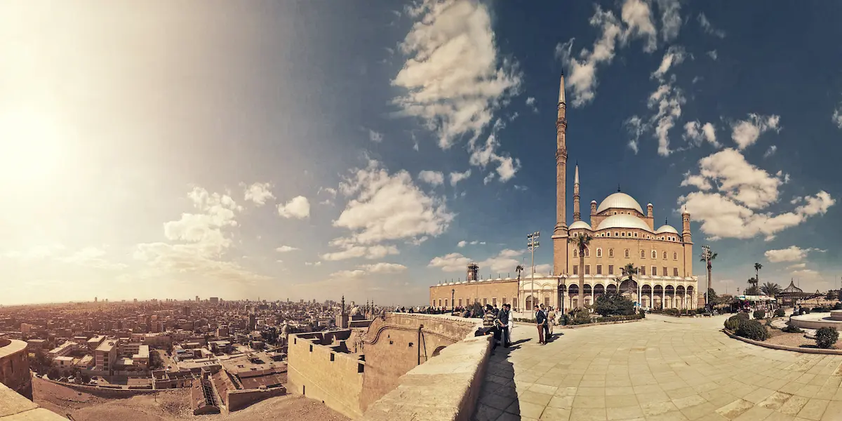 The Mohamed Ali Mosque in Cairo, featuring its grand domes and minarets, set against the city's skyline.