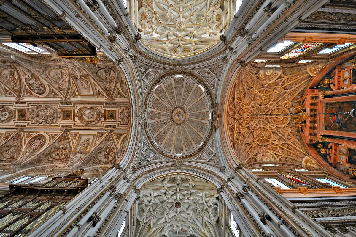 Interior view of the Mosque of Córdoba dome, built in 785 AD, with intricate geometric patterns and elegant arches.