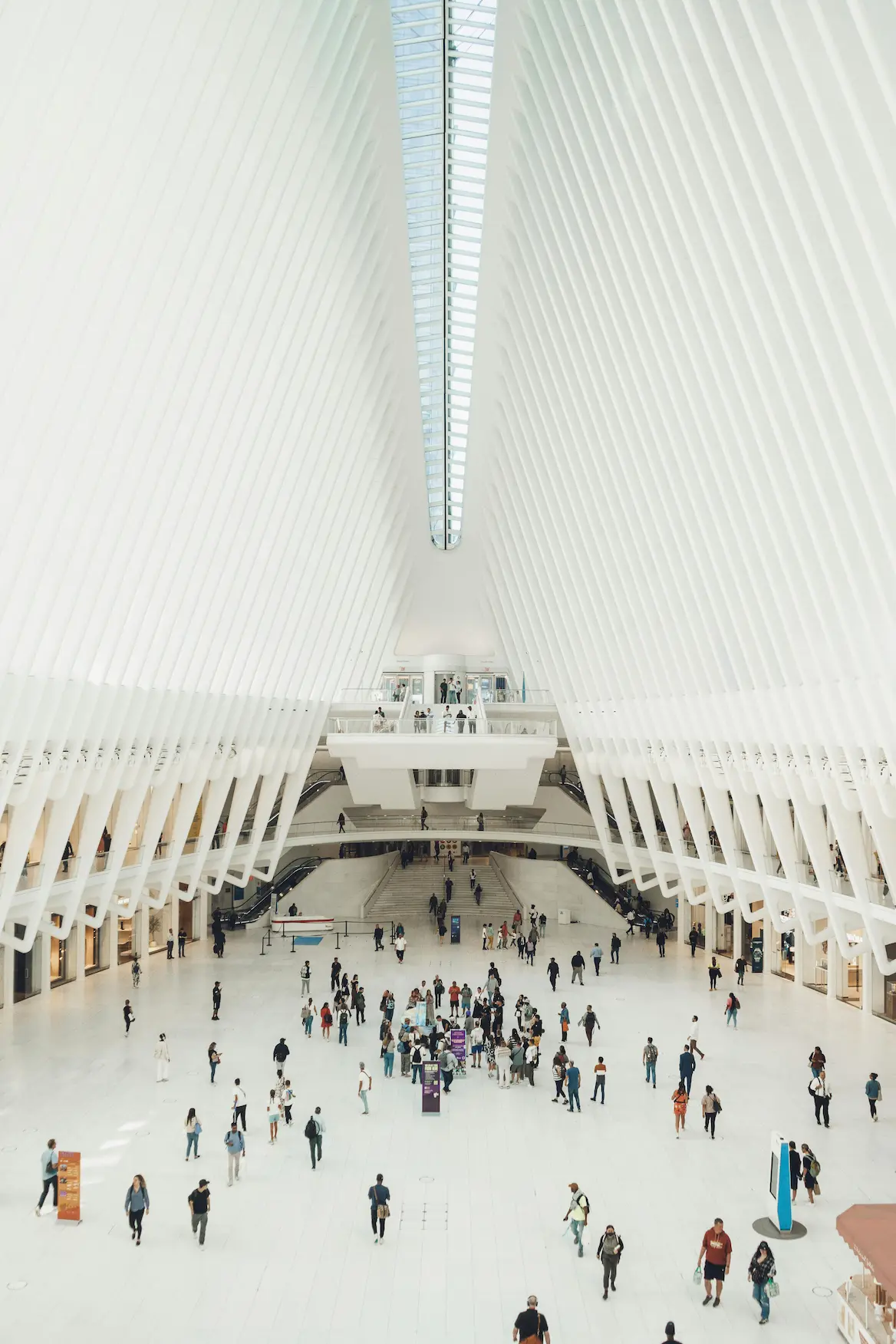 interior view of the Oculus in New York, featuring soaring white arches and visitors exploring the space