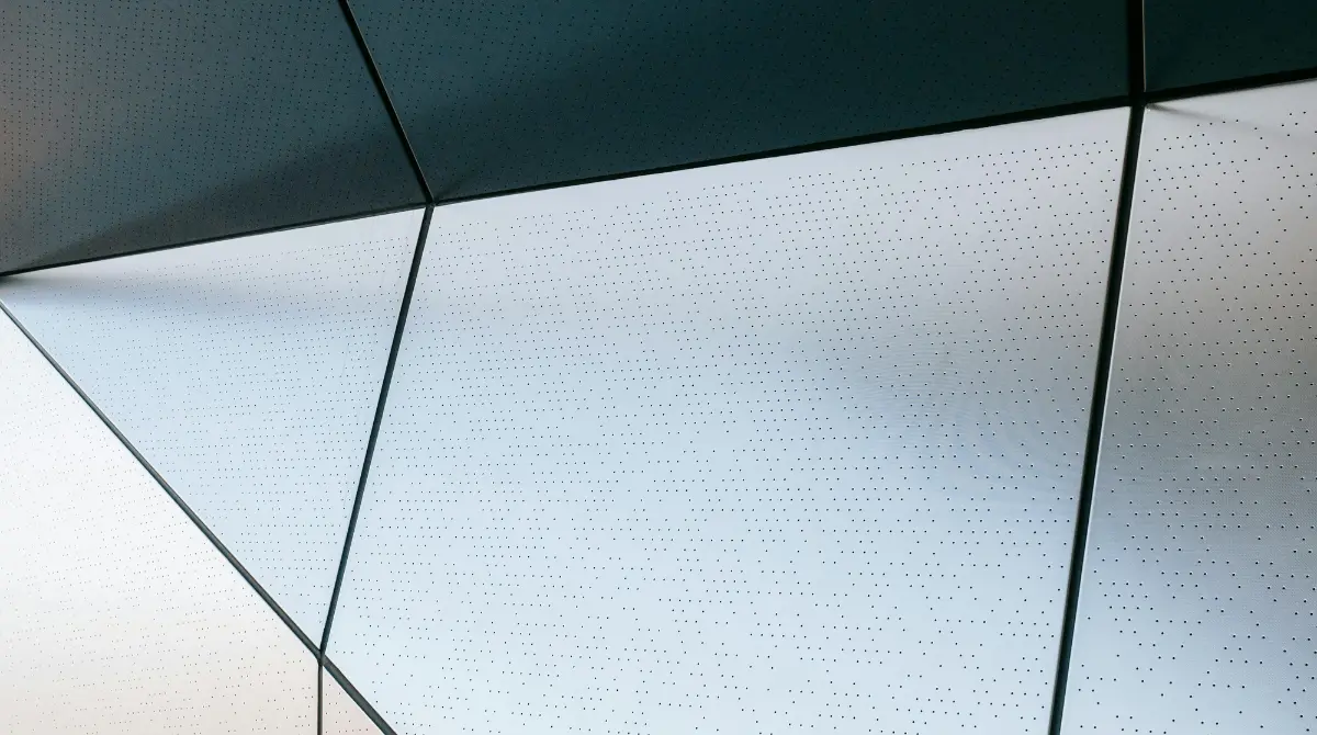 A geometric building featuring a sleek metallic wall, showcasing a modern prefab metal structure.