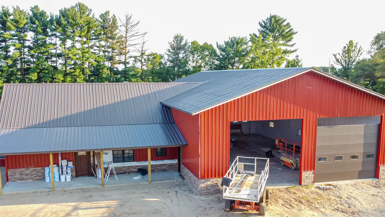 barndominium with red colors situated on a farm