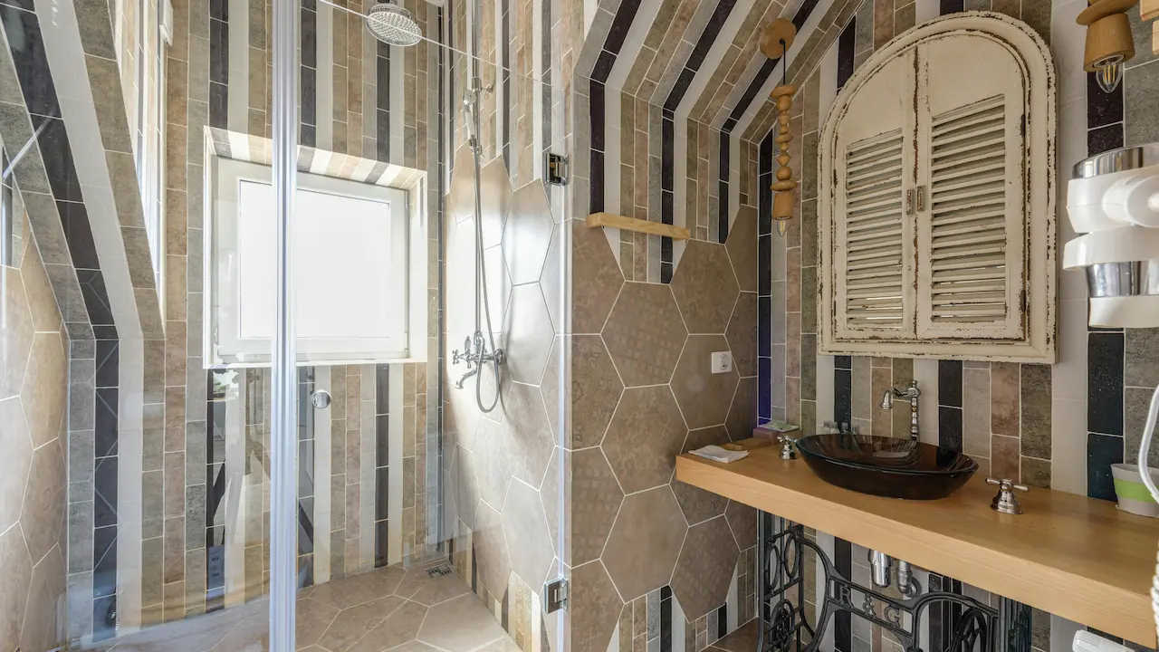 Shower in an elegant rustic bathroom with natural materials and warm tones.