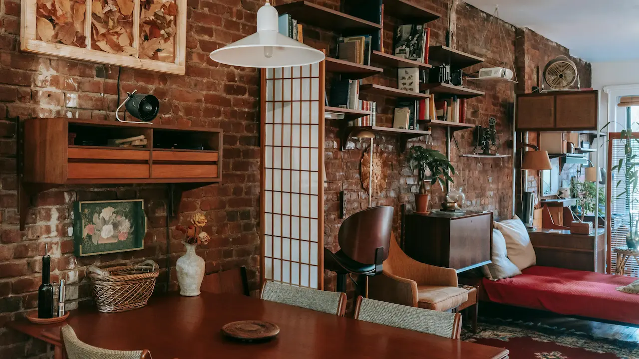 Rustic interior with dining area and bed in a stylish flat with brick walls.