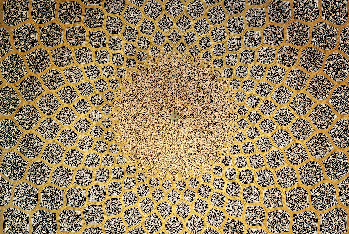Interior view of the Sheikh Lotfollah Mosque dome, showcasing intricate calligraphy and symmetrical patterns.