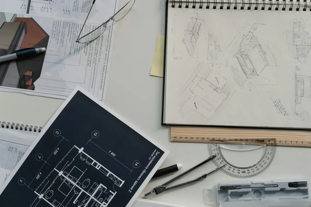 Student working on an architectural blueprint at a drafting table, learning beginner architecture lessons.