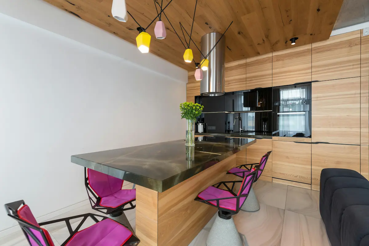 Interior of a tiny modern house kitchen, featuring stylish lamps and smart storage solutions.