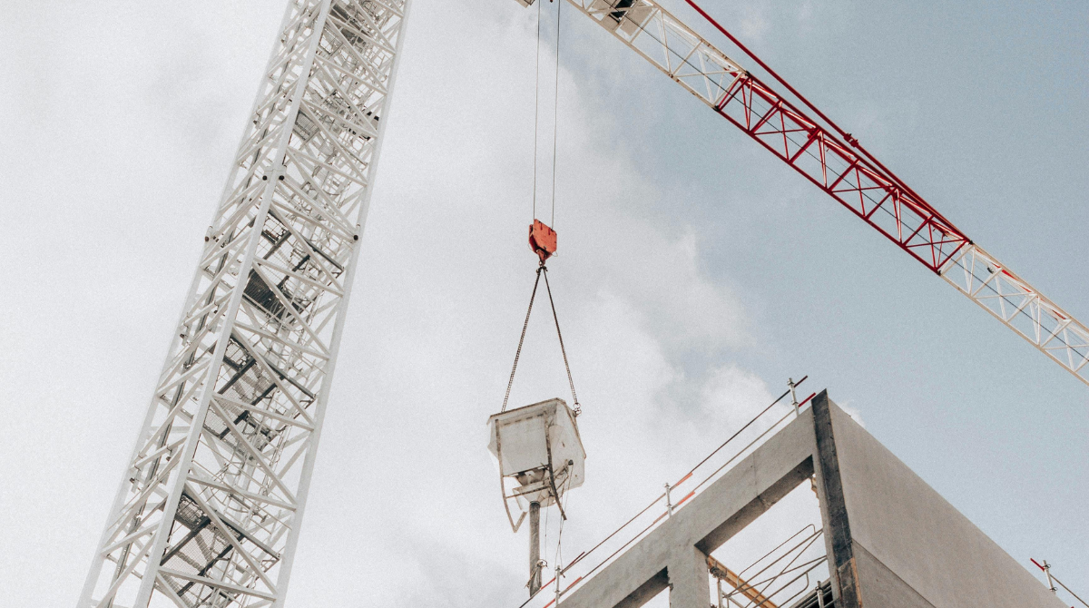 A towering crane at a modern construction site, lifting materials for high-rise development.