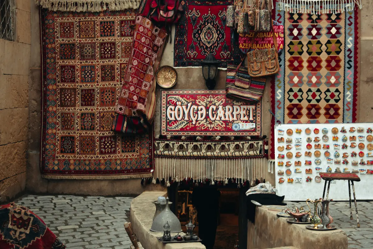 Traditional carpets displayed in a bazaar in Baku, Azerbaijan, creating a vibrant arts and crafts interior.
