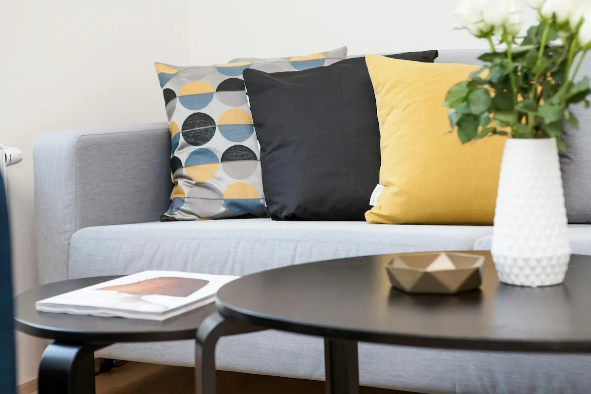 Two small round coffee tables in front of a sofa, enhancing the minimalist living room with inviting curves that soften the space.