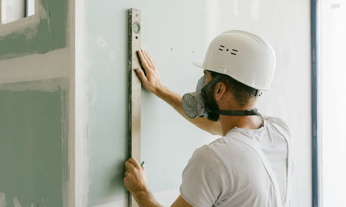 worker fixing minor cracks on a wall during home repair