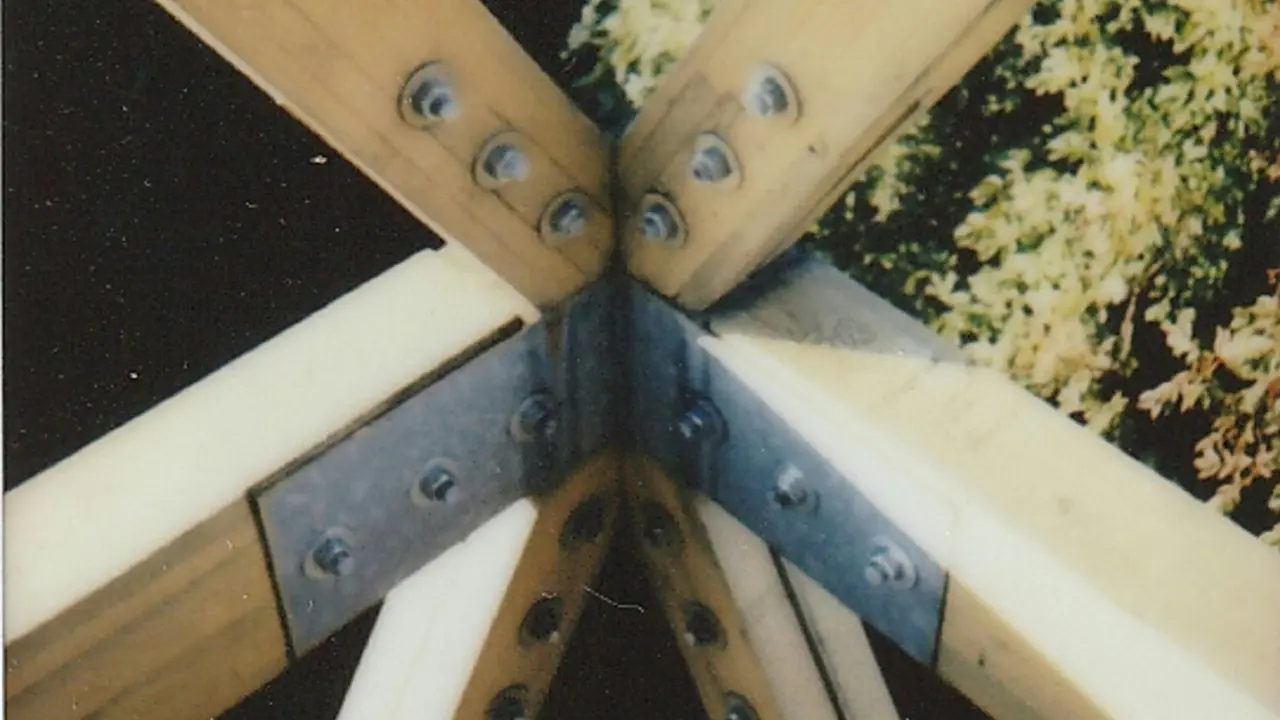 Extreme close-up of a roof truss joint, showing detailed connections and fasteners for structural stability.