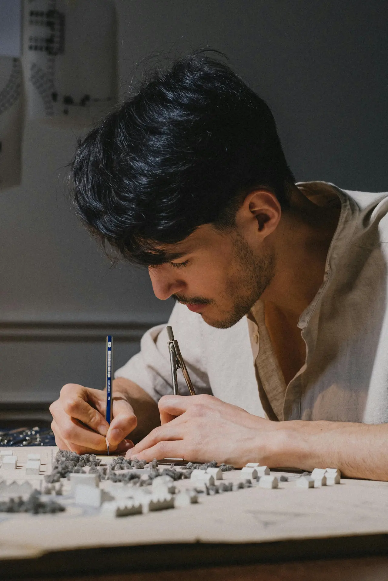 An architect working on an architectural model using a precision knife, showcasing attention to detail and craftsmanship.