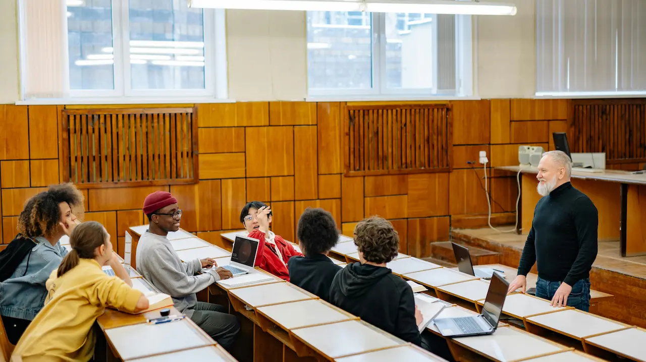 University architecture students studying and discussing designs with a professor in an engaging learning environment.
