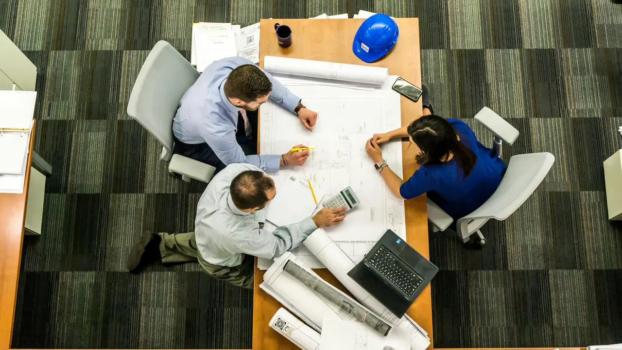 A homeowner and architect reviewing a blueprint, discussing home design details.