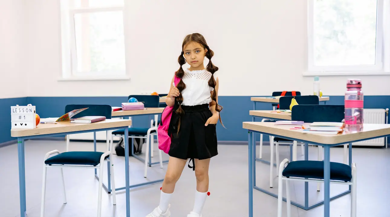 A girl posing in a classroom, excited about learning architecture and ready to explore new concepts.