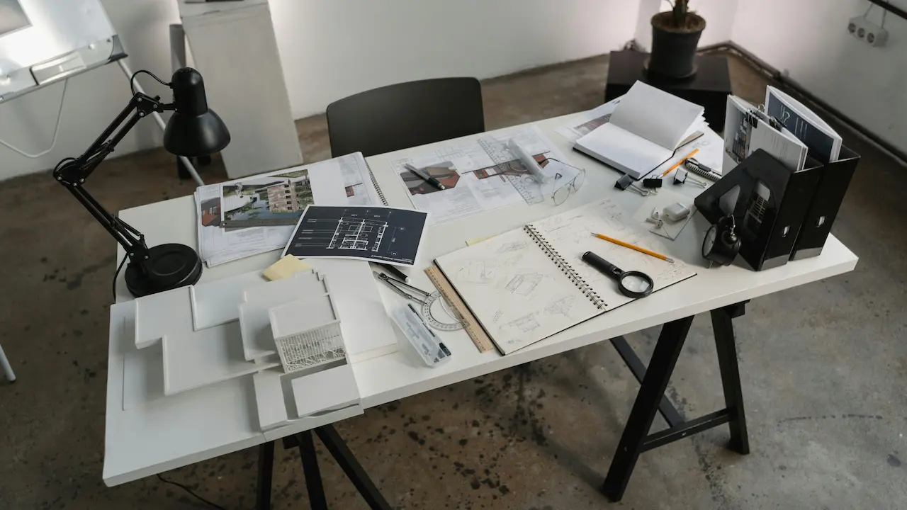 Floor plans laid out on a white table, part of the architecture model-making process, showcasing design and planning stages.