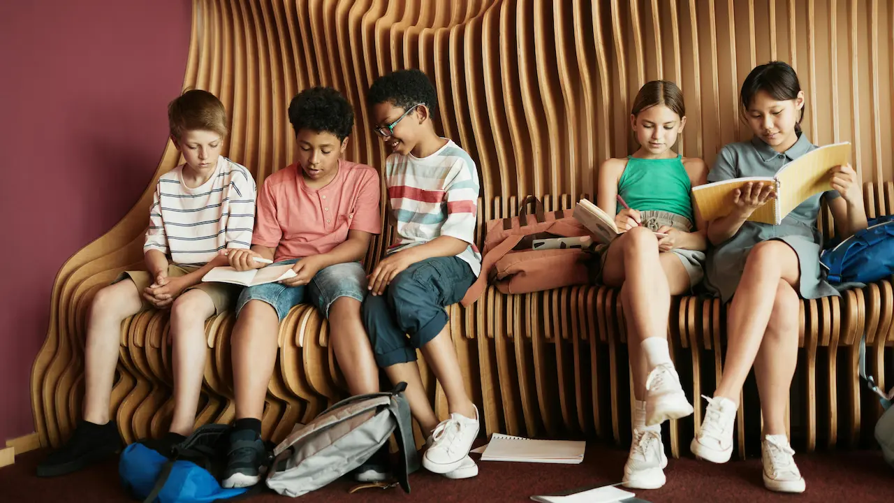 Kids sitting on a bench with architectural design, engaging in a hands-on learning experience about architecture.