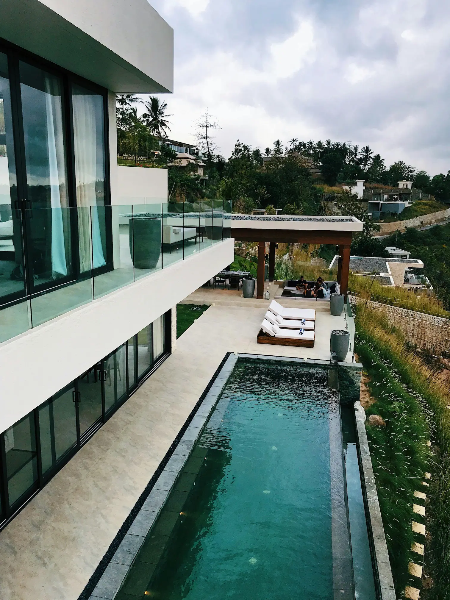 Luxury home with a custom long, narrow pool near a concrete walkway, showcasing high-end design features.
