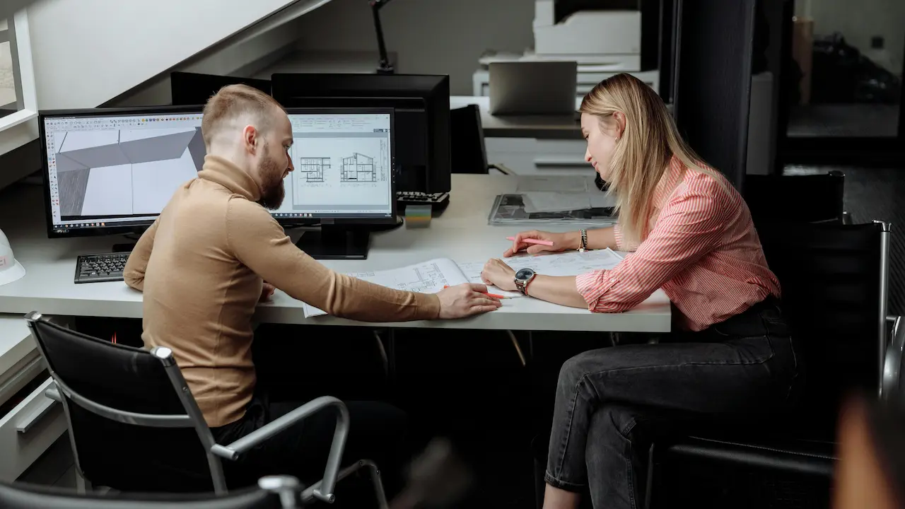 A prospective homeowner working with an architect, reviewing plans for a future home.