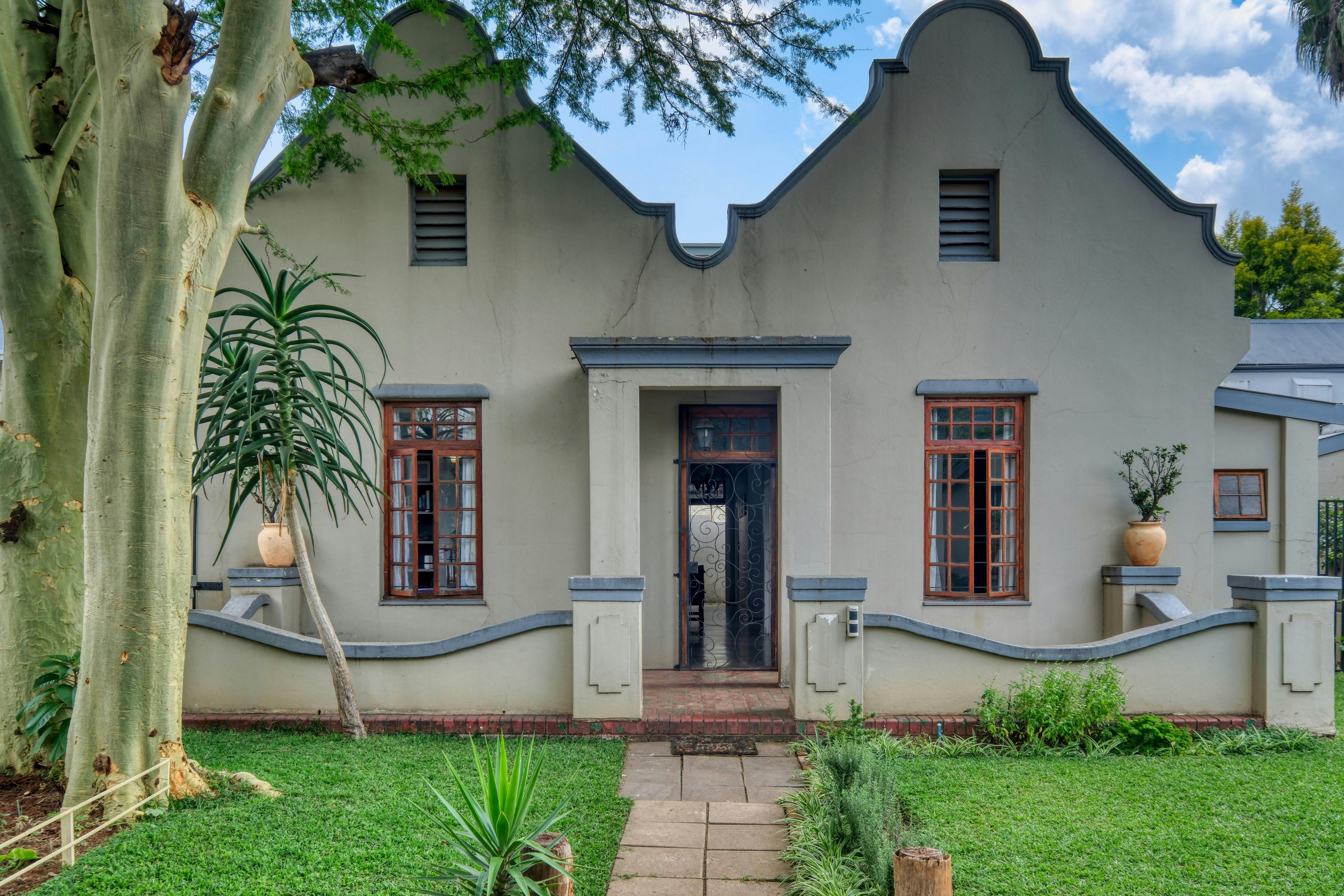 Charming 1940s-style historic house exterior with garden in Pretoria, South Africa.