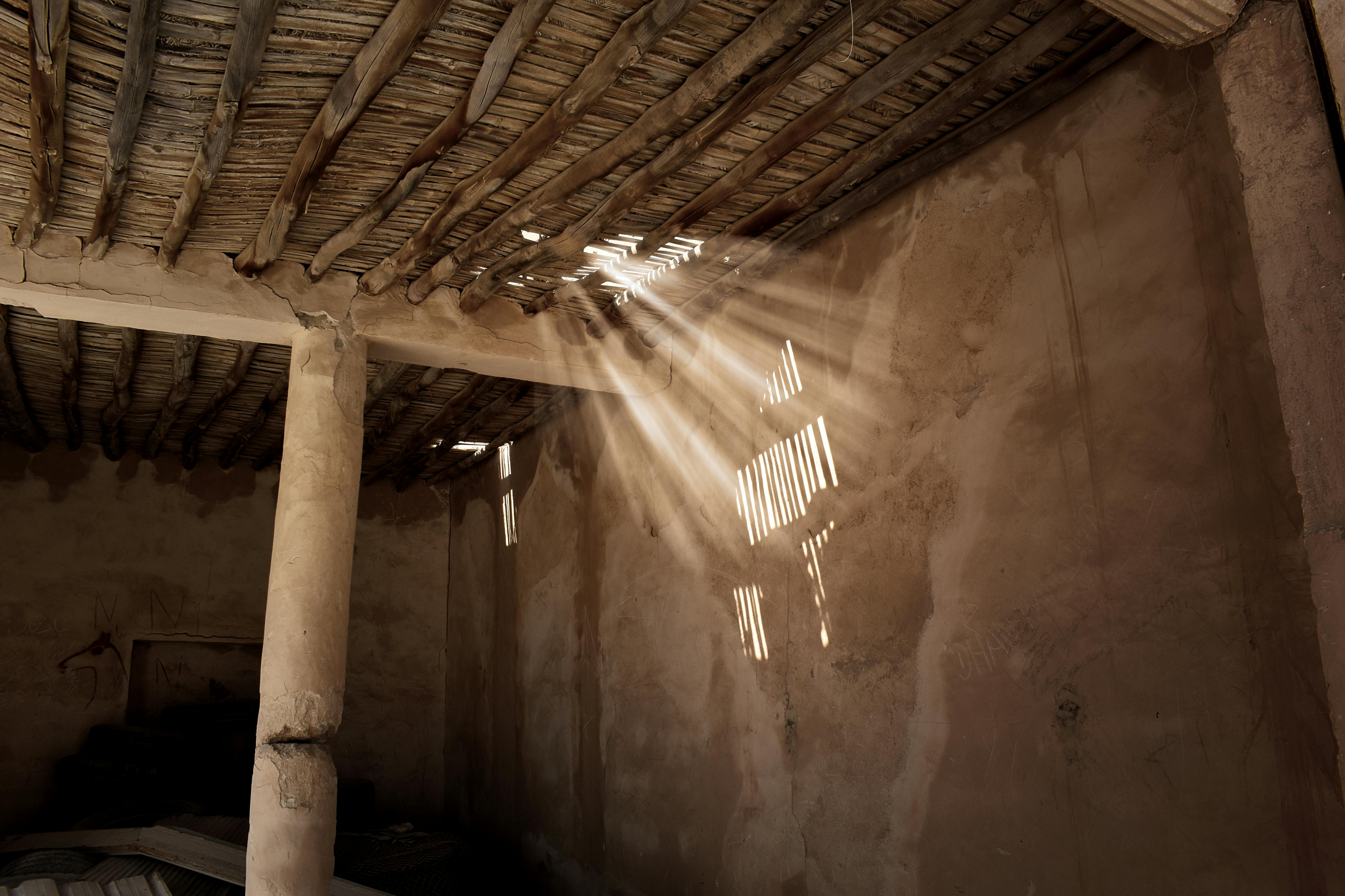 Room in an abandoned building, showcasing mud and bamboo architecture with weathered walls and rustic elements.