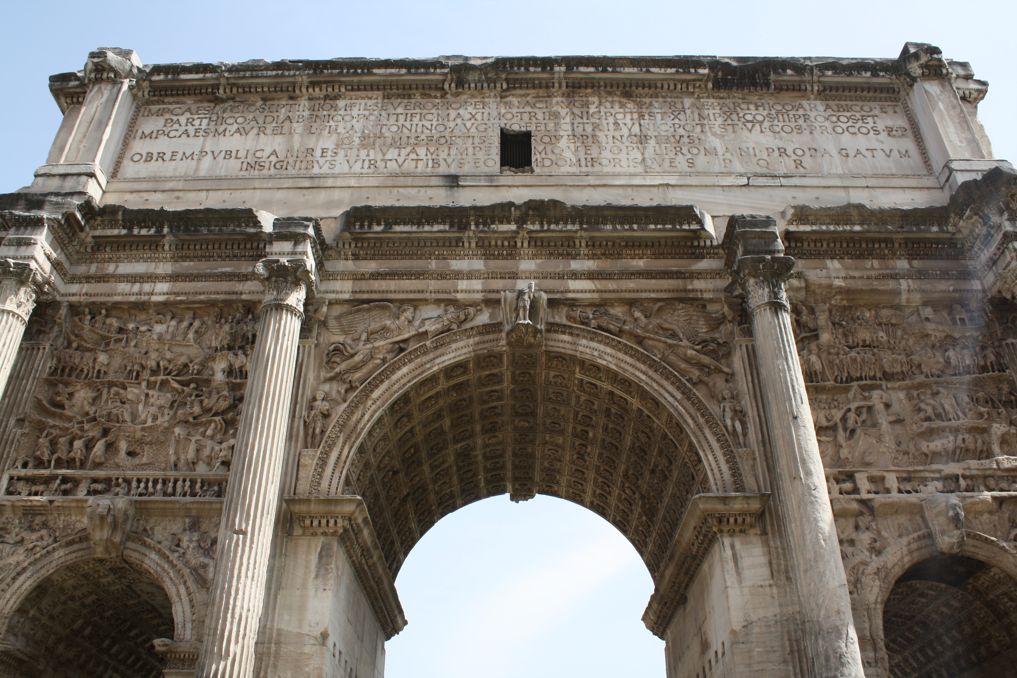 Arch of Septimius Severus in Rome with intricate carvings and three archways.