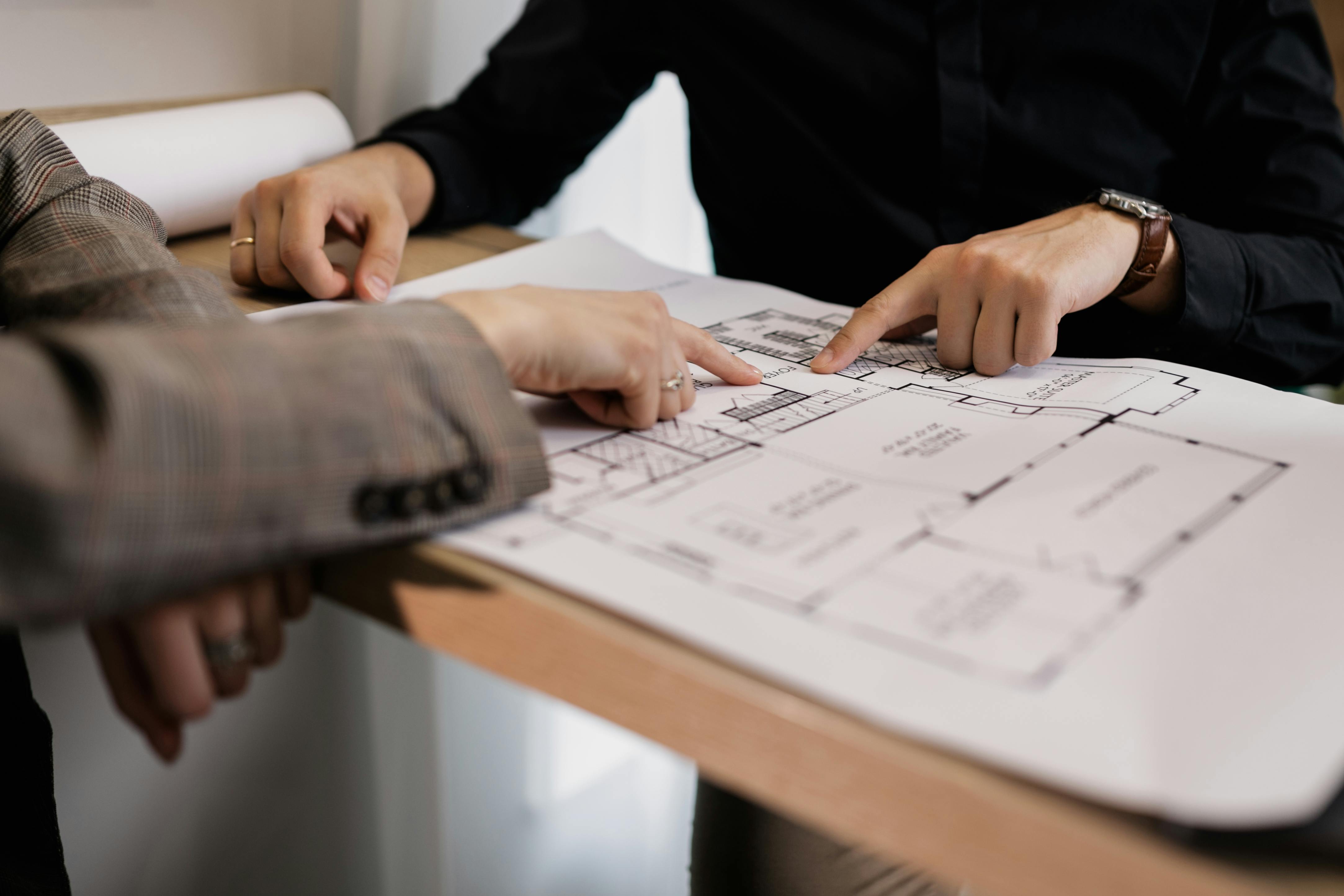 An architect and client reviewing a detailed floor plan, discussing design elements.