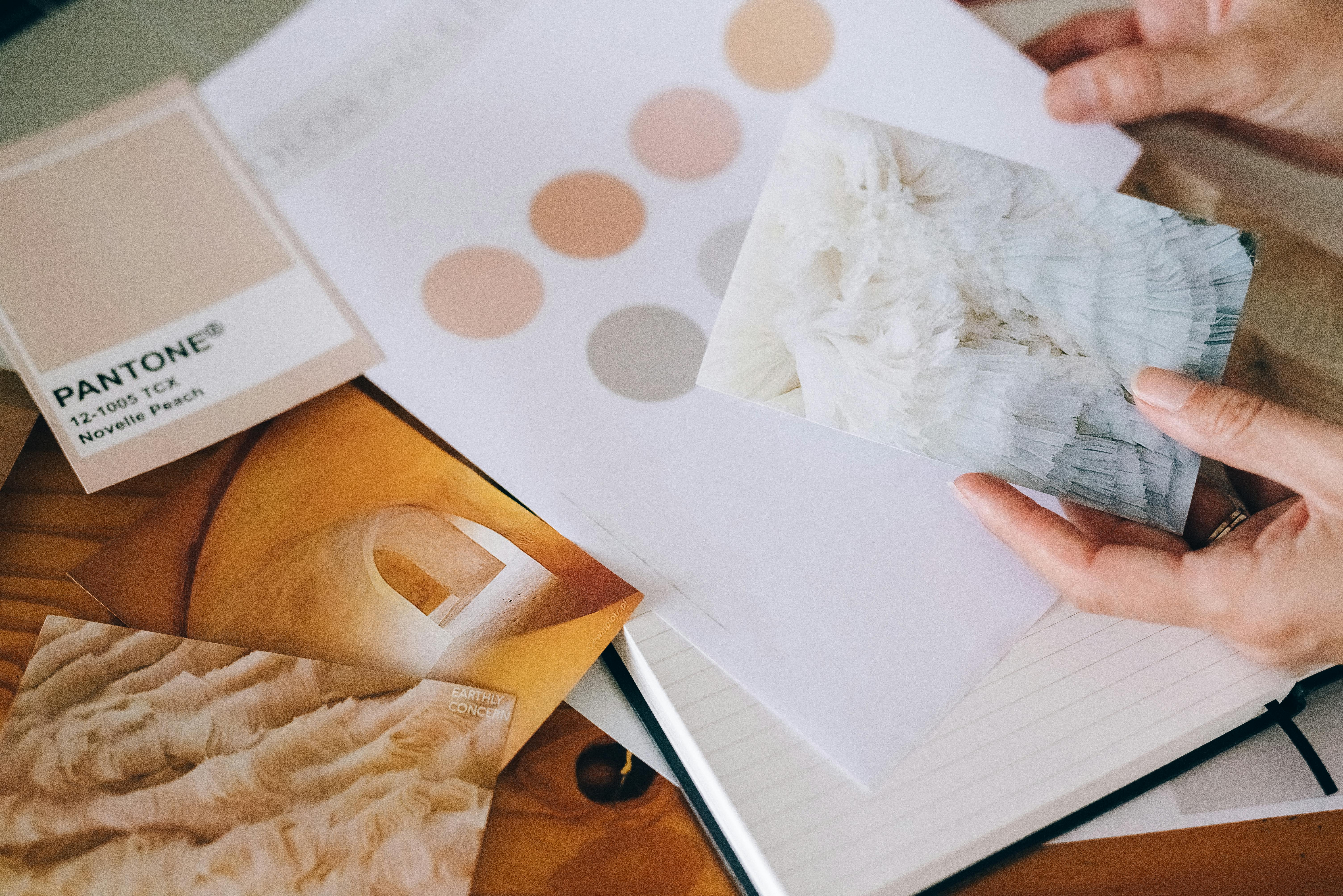 Architect holding a card over paper and a notebook, showcasing fundamental design elements.