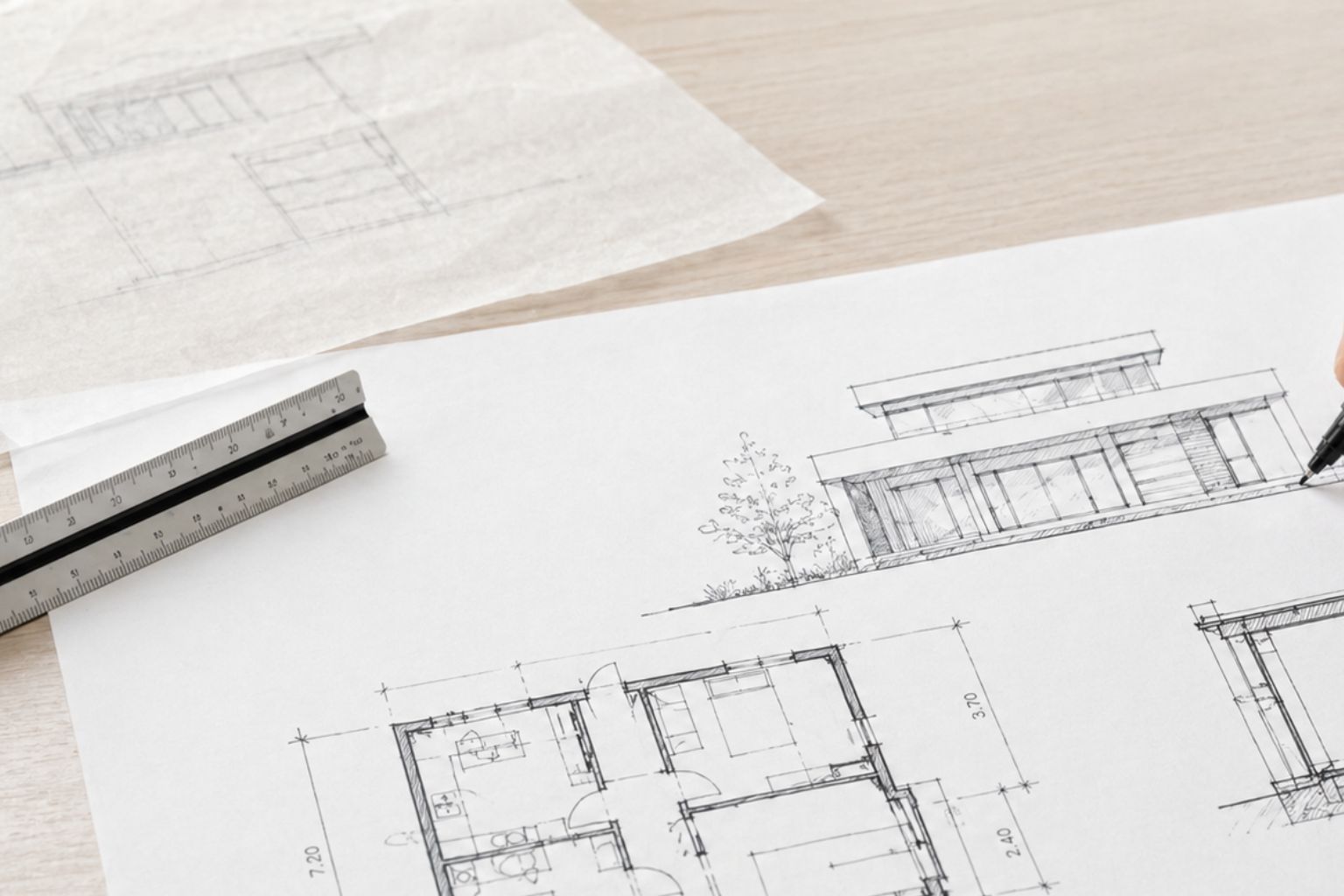 Architect sketching floor plans and building details on a drawing sheet with a technical pen.