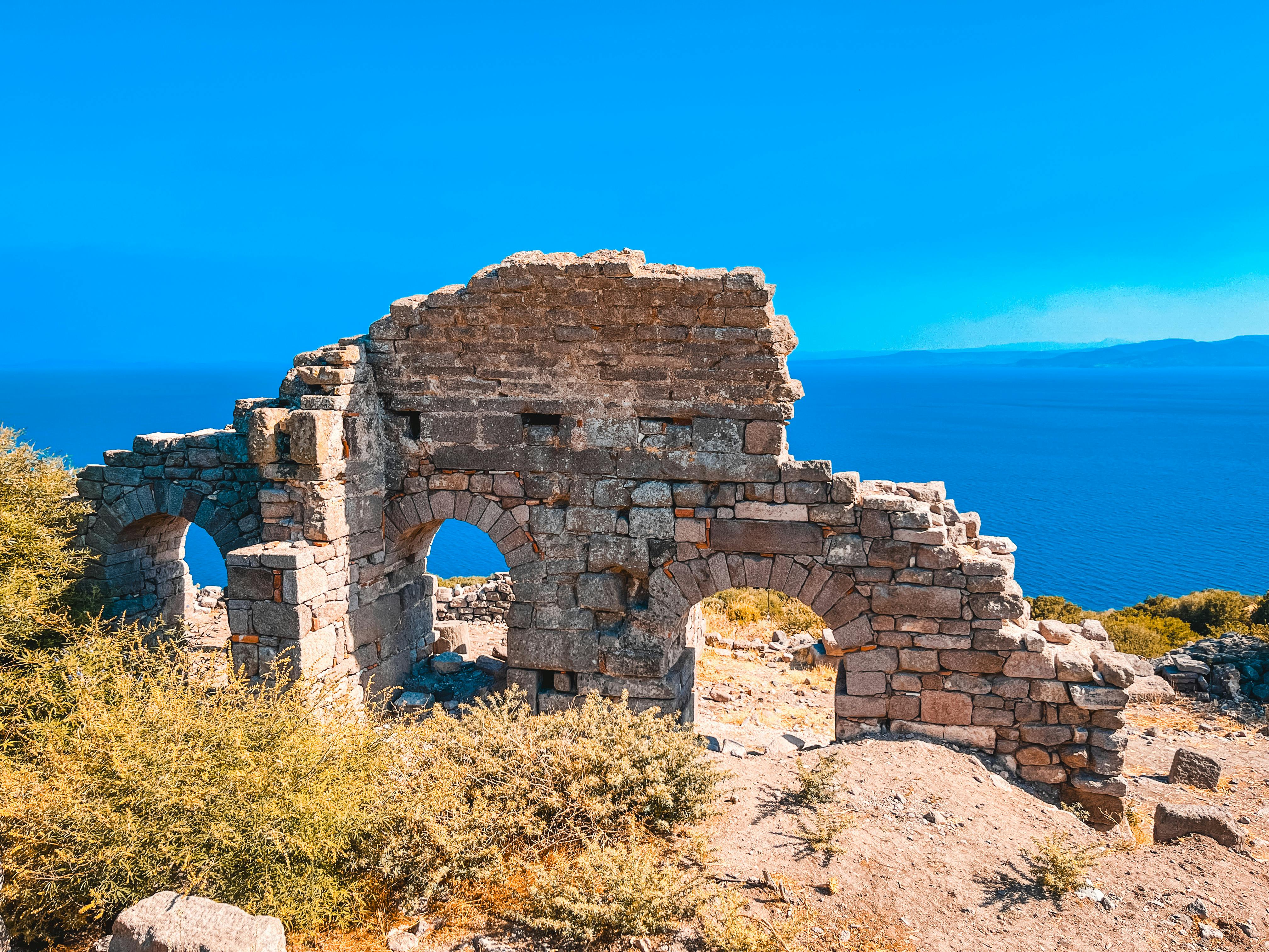 Ancient stone ruins in Assos overlooking the Aegean Sea
