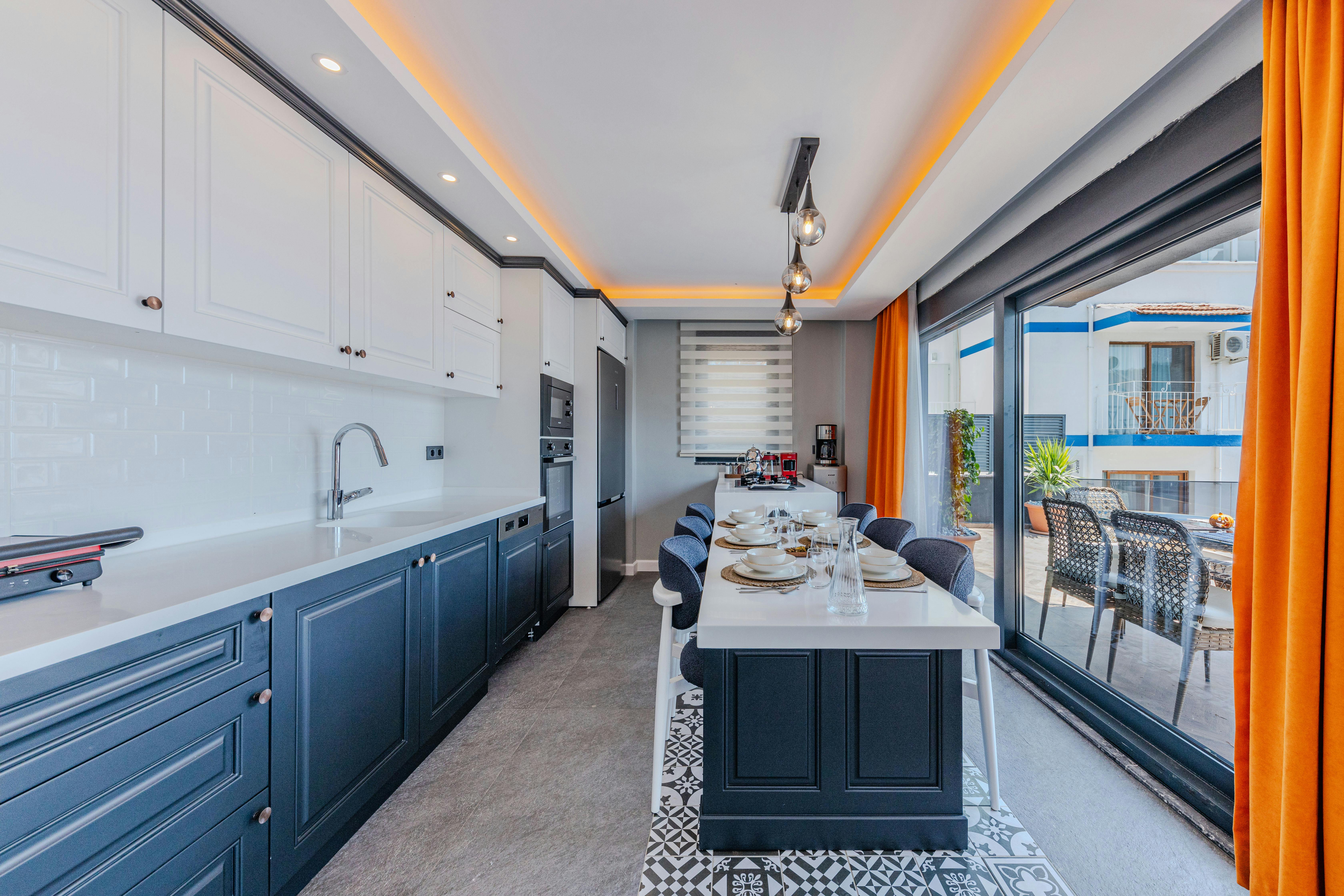 Modern kitchen with white upper and blue lower Shaker-style cabinets.