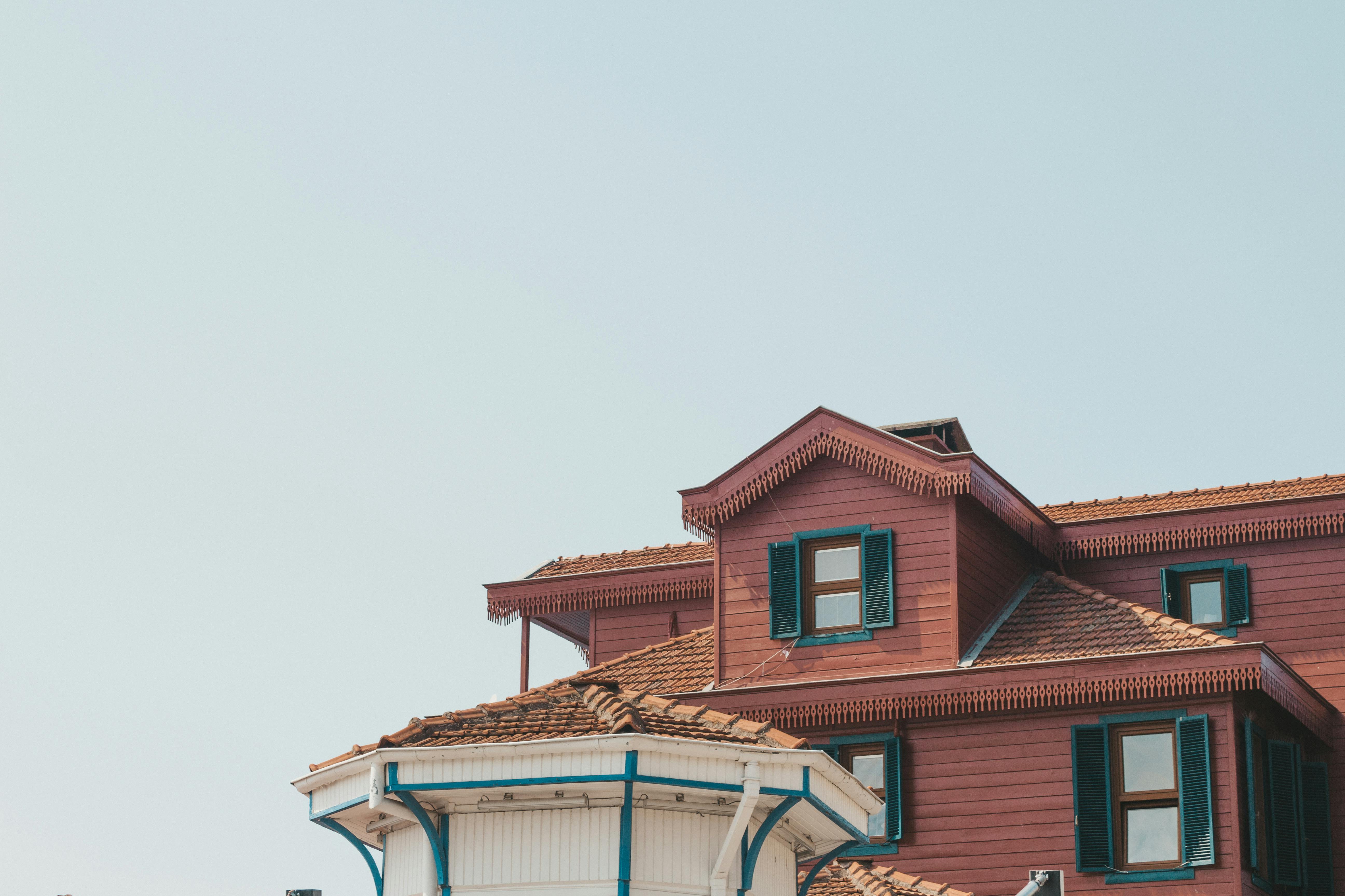 Modern brown house featuring both hip and gable roof styles.
