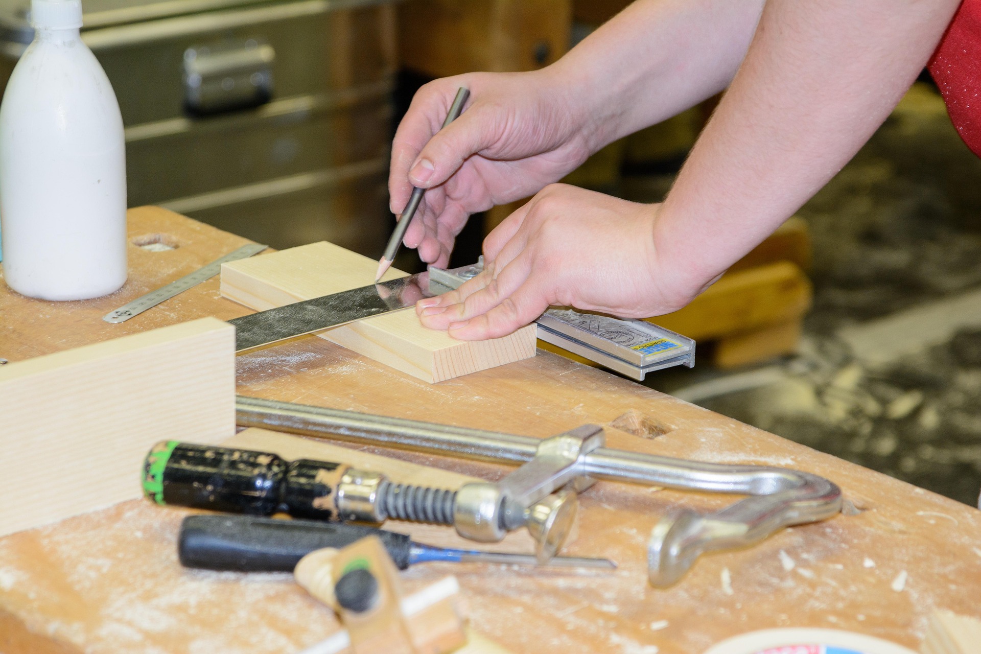 A carpenter skillfully using manual tools, such as a hand saw and chisel, to carefully shape a piece of wood.